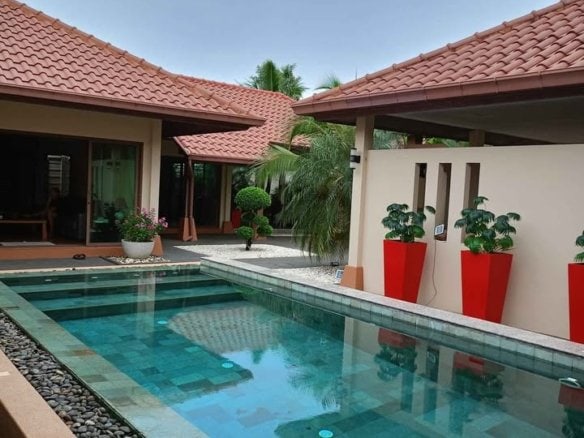 Modern luxury home with swimming pool and red tile roof courtyard