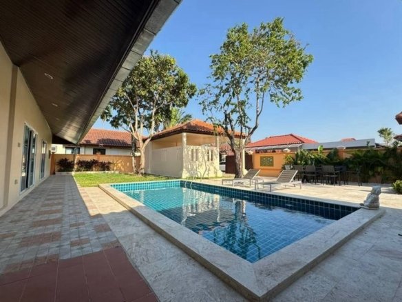 Residential backyard with rectangular swimming pool and tropical landscaping