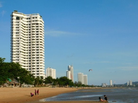 Beach resort high-rise buildings with sandy shore and swimmers