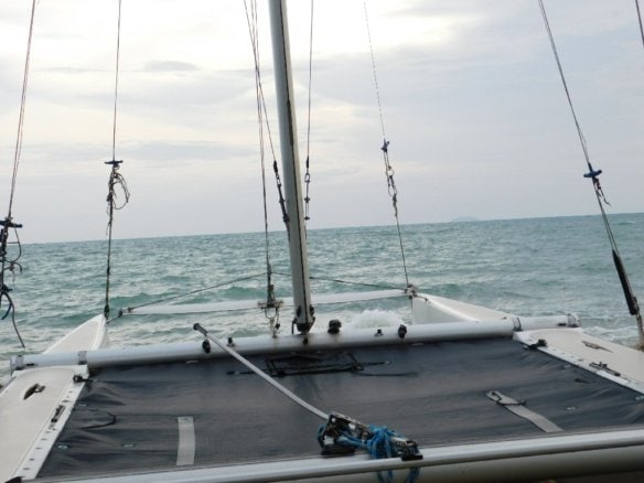 Catamaran sailboat deck with rigging and ocean horizon view