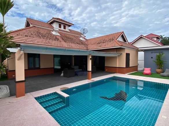 Modern poolside home with terracotta roof and covered patio area