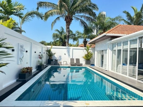 Modern luxury villa with turquoise swimming pool and palm trees