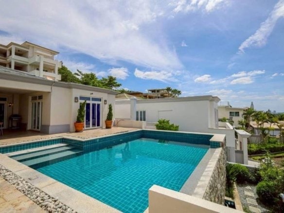 Modern luxury home with turquoise swimming pool and white architecture