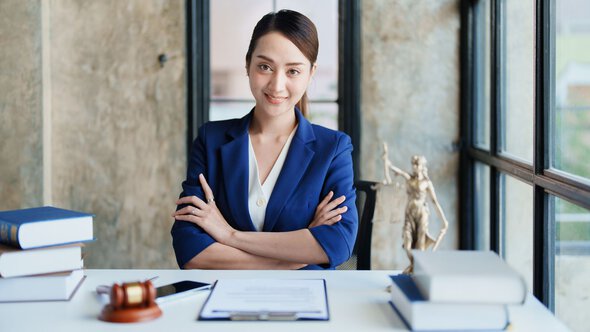 A professional woman in a business suit seated at a desk, symbolizing law school consultancy and expert guidance for applicants.