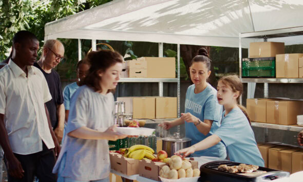 caucasian girl packs free food to be distributed to the underprivileged with assistanc SBI 350465406