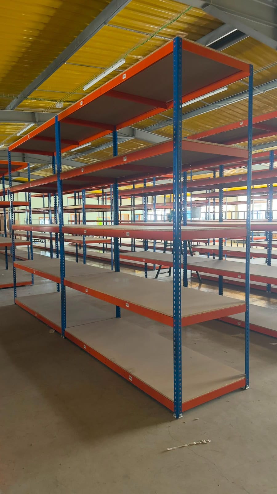 Estantería Mecalux carga manual para almacén con estructura azul y largueros naranjas