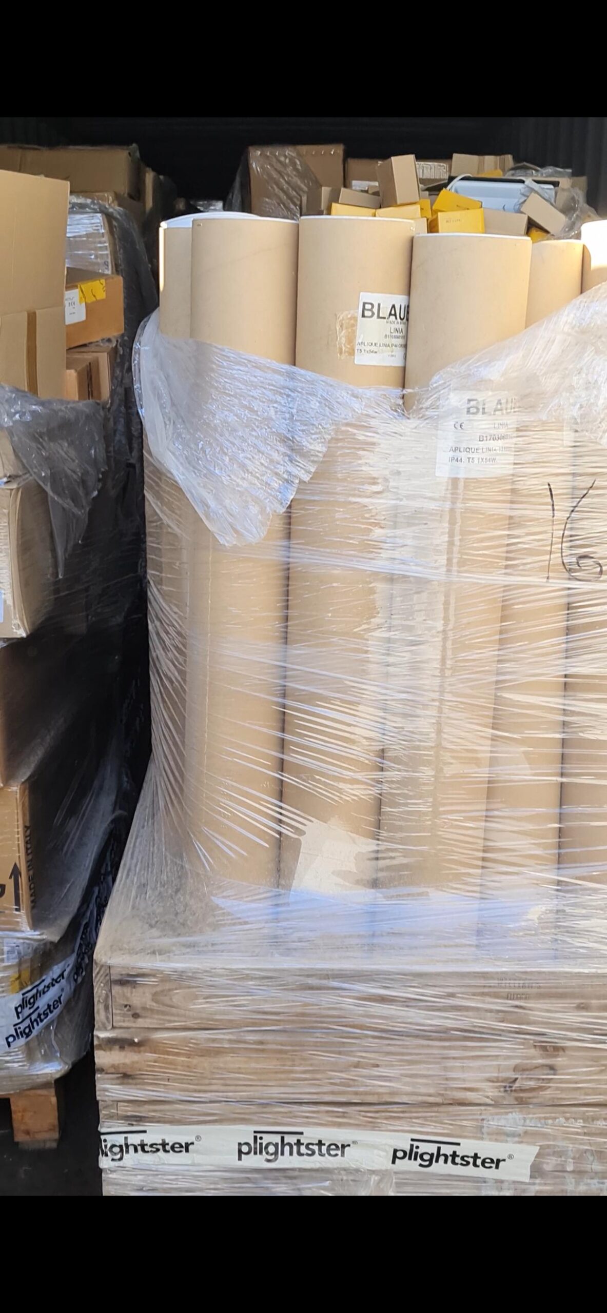 Cajas y palés del lote de luminarias nuevas con diferentes modelos y referencias.