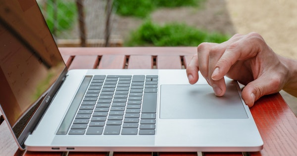 Personne sur son laptop sélectionnant un logiciel