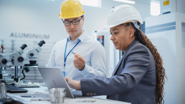 two technicians referencing a laptop