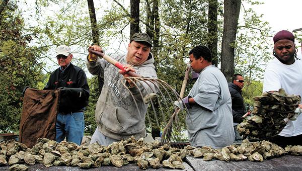 Denis Perec of Norfolk loads fresh oysters onto the pit during a previous Chuckatuck Ruritan Club Oyster Roast at Kirk Farm on Everets Road. This year’s installment is set for April 8.