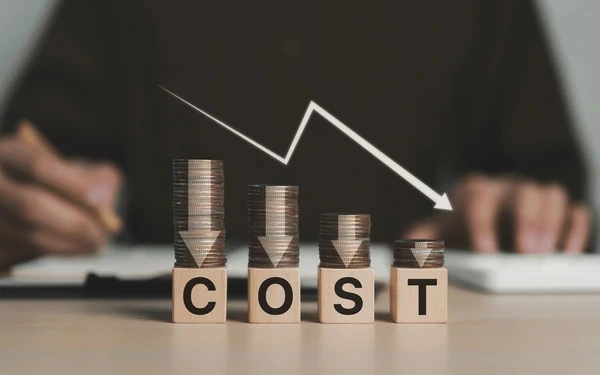 Cost reduction concept with decreasing coin stacks and downward arrow chart
