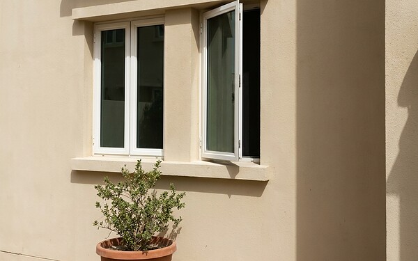 White aluminium casement windows opening outward on an Abu Dhabi townhouse facade