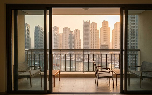 Slim-framed sliding door framing a marina and skyline view