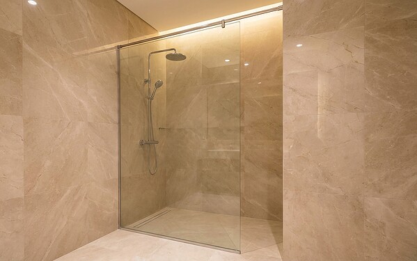Semi-frameless glass shower screen with support bar in a modern Dubai bathroom
