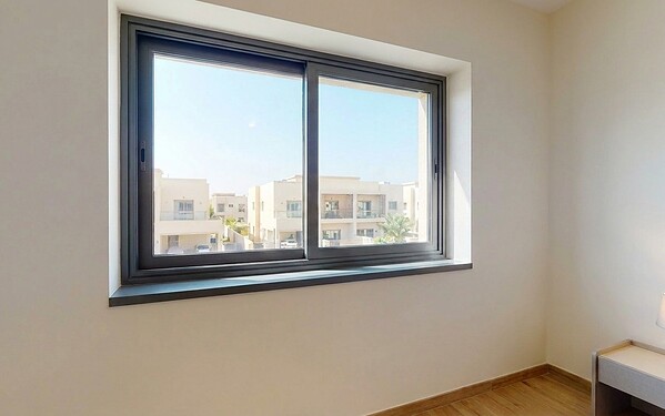 Aluminium sliding window on a track in a Dubai apartment overlooking neighbouring villas