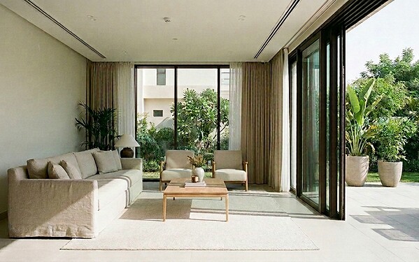 Multi-slide telescopic aluminium doors stacked open across a wide terrace opening in a Dubai villa