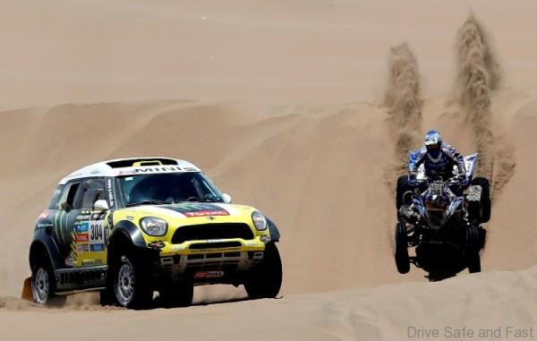 Nani Roma of Spain (L) drives his Mini beside Sergio Lafuente of Uruguay on his Yamaha quad during the ninth stage of the Dakar Rally 2014, from Calama to Iquique, January 14, 2014.               REUTERS/Jean-Paul Pelissier (CHILE - Tags: SPORT MOTORSPORT)