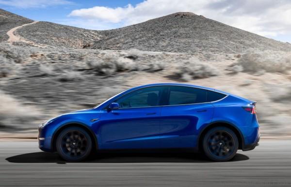 Tesla Model Y side profiel in motion in blue