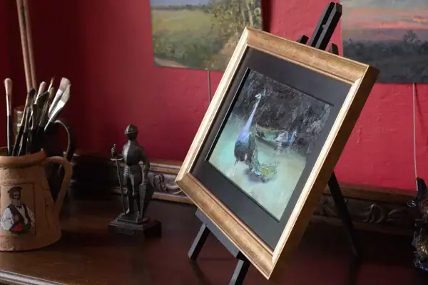 Side view of framed Pavoni peacocks oil painting with gold frame