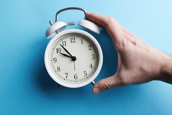 White Vintage Alarm Clock On Empty Blue Color Background - Auster Inteligência Contábil