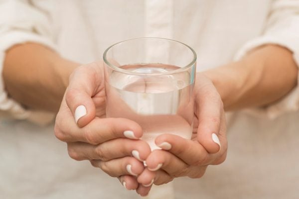 woman-holding-glass-filled-with-water