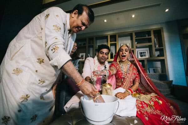 Bride and groom search for the ring in a bowl during the welcome home games