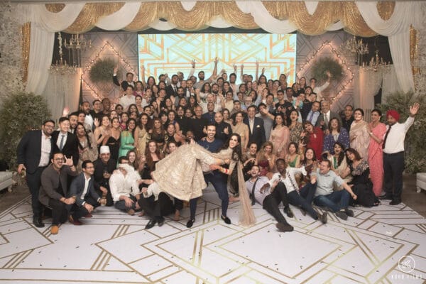 Group photo of guests with the bride and groom at a Sikh wedding reception