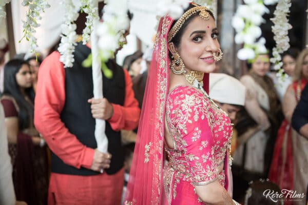 Bride walks in with her family before the Anand Karaj