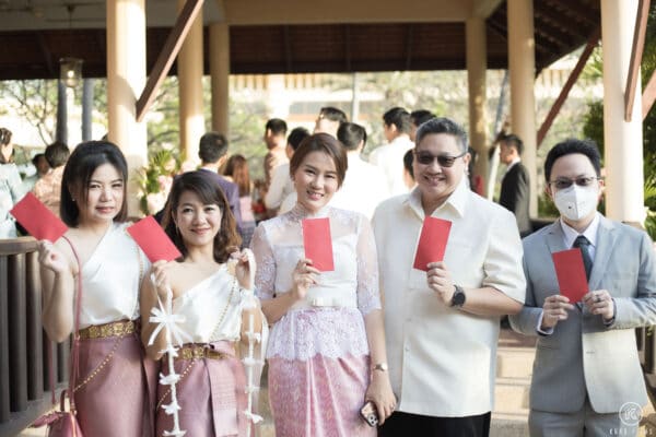 The bride's friends show the red envelopes they won from the groom at the door games at Dusit Thani Hua Hin