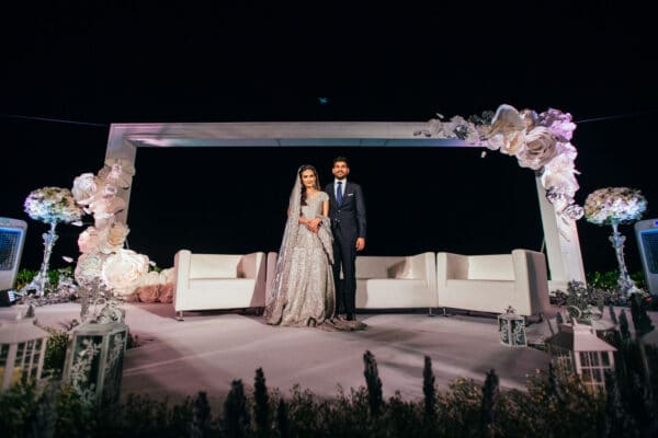 Bride and groom pose on the outdoor Walima stage at night in Hua Hin