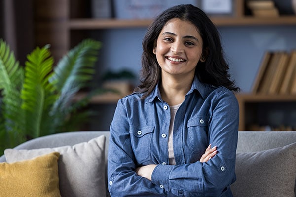 The girl has her arms crossed over her chest and is smiling in the psychologist's office