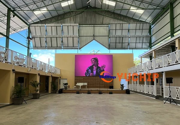 Full view of the installed 6.72x3.84m outdoor LED display (P3 iron box series) showing content on stage at a hotel venue in Barbados