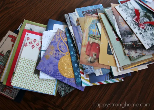 Stack of greeting cards on table for upcycled christmas cards craft.