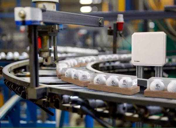Cadena de producción con bolas de golf en una cinta transportadora, utilizada en una noticia.