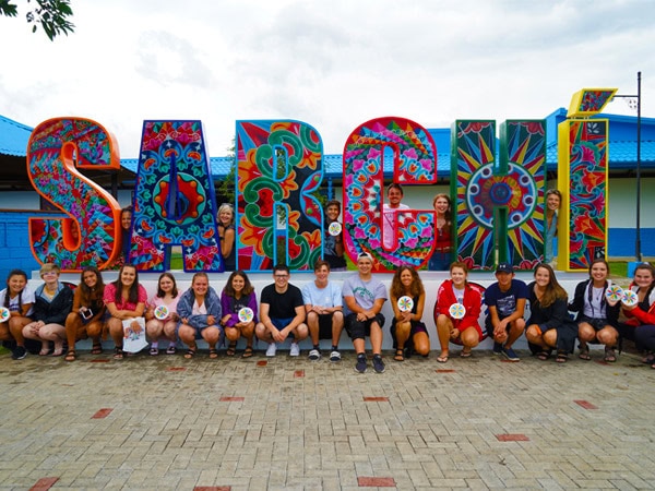 ACIS travelers pose in front of the Sarchí sculpture with their artwork