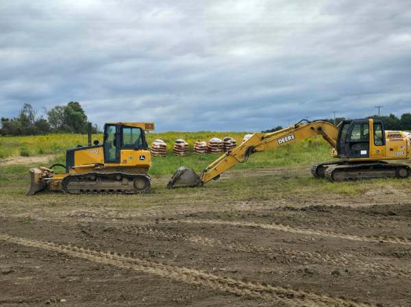 Land Clearing in Jamestown, NY John Deere dozer and tracked excavator parked side by side on a worked field