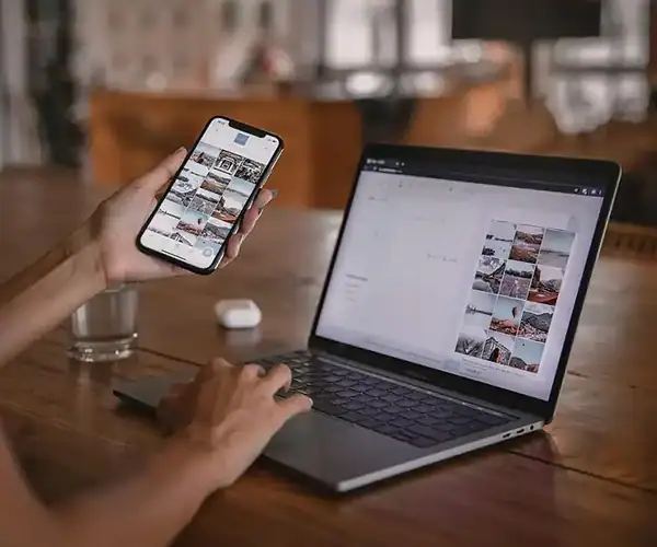 Webdesign und Social Media Management Person arbeitet an Laptop und Smartphone für Webdesign und Social Media.