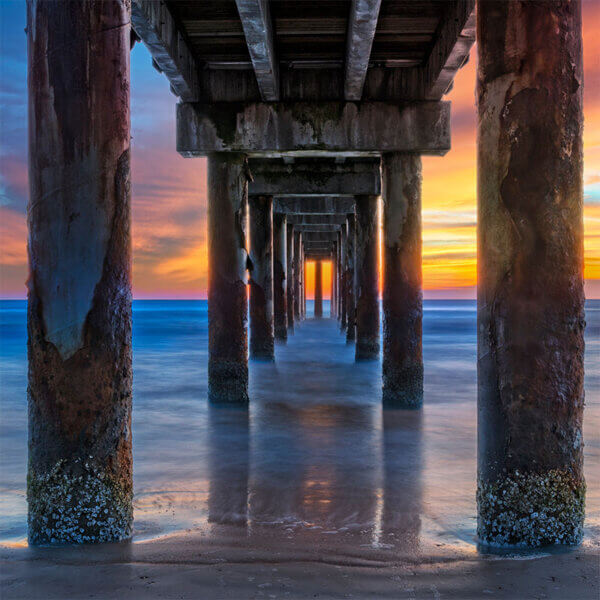 under the St Augustine Beach pier looking out to the ocean at sunset