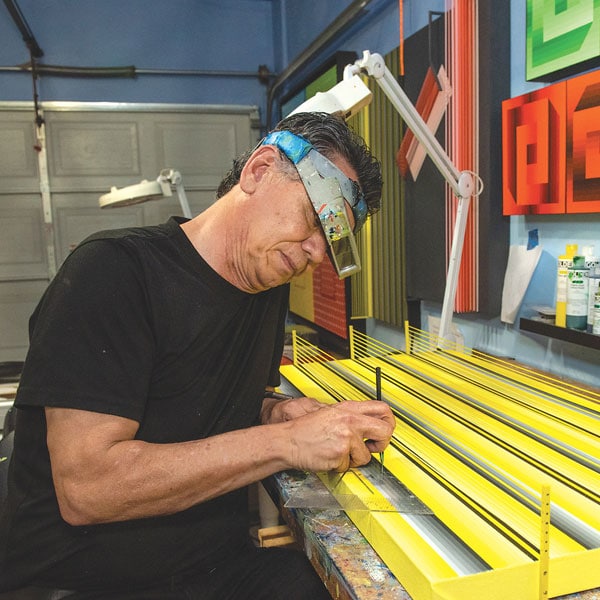 Op-Artist Henry Parada works in his basement studio