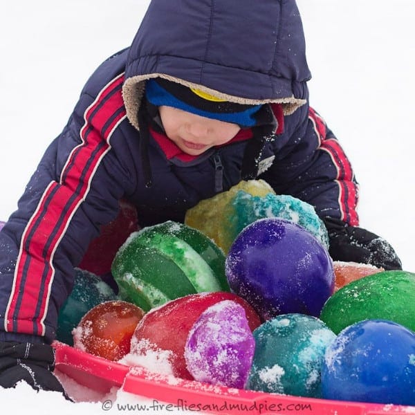 child playing with winter ice jewels in the snow