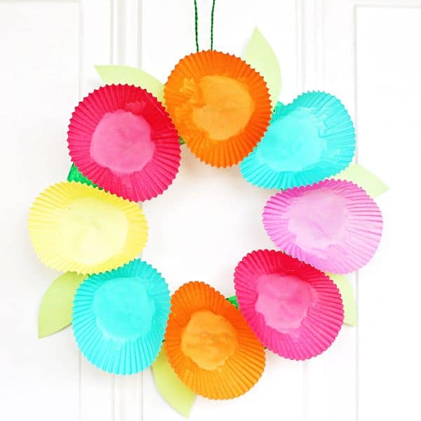 spring wreath craft for kids made out of a paper plate and cupcake holders