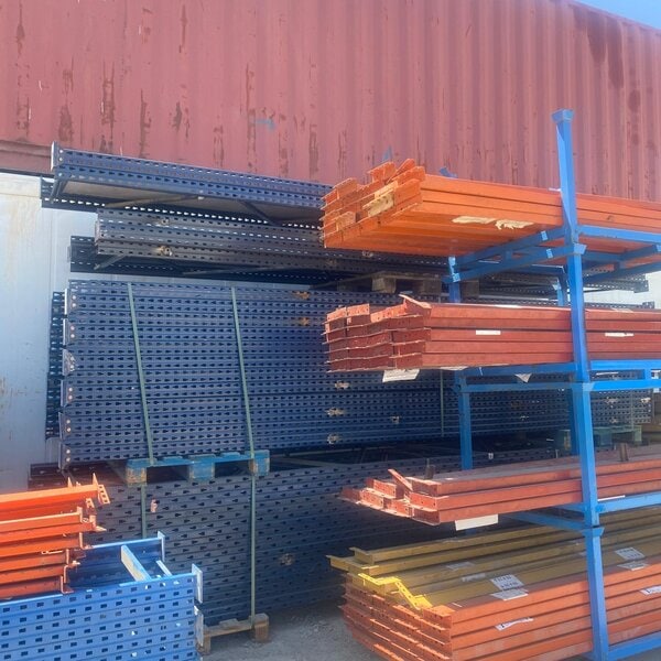 Estantería industrial para paletización con mástiles azules de 4,5 m y travesaños naranjas de 2,7 m.
