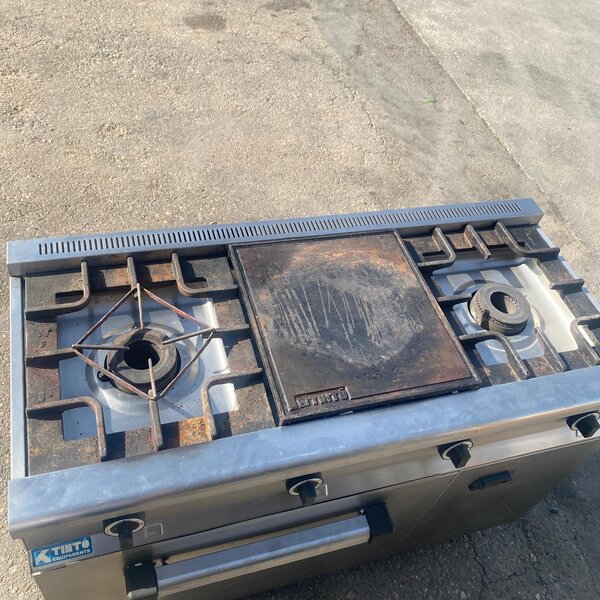 Cocina industrial de gas con horno y plancha con dos fogones superiores y plancha central