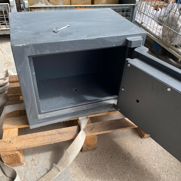 Interior de caja fuerte usada con llave y puerta abierta