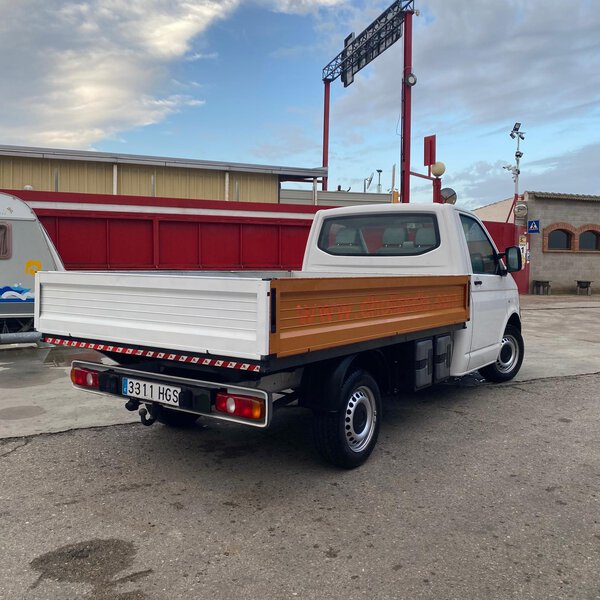 Vista trasera de Volkswagen Transporter con caja abierta y laterales metálicos.