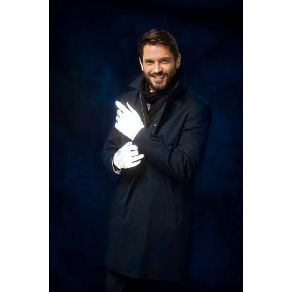 Miehen kädessä Huomio Sports Tech heijastinhanskat. Hyvin näkyvät pimeällä.