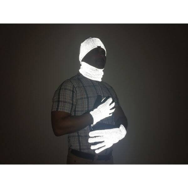 Heijastavat Magic-tuotteet: pipo, hanskat ja kauluri miehen päällä pimeässä.