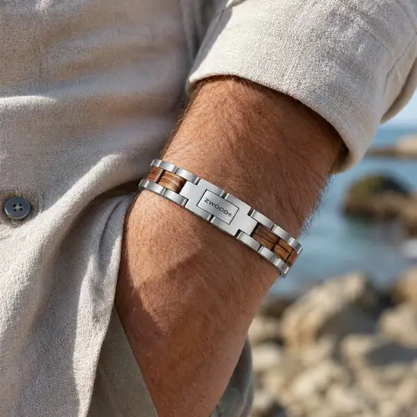 Bracelet Zwood® en acier argenté et bois clair porté au poignet dans une ambiance bord de mer