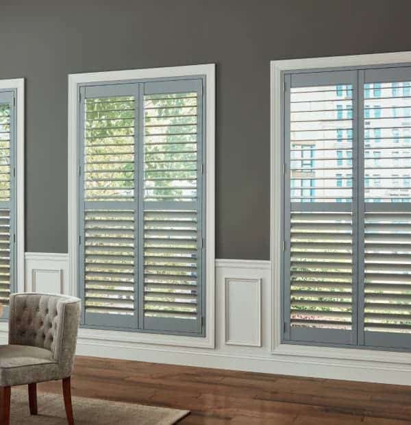 Elegant plantation shutters with adjustable louvers on large windows.