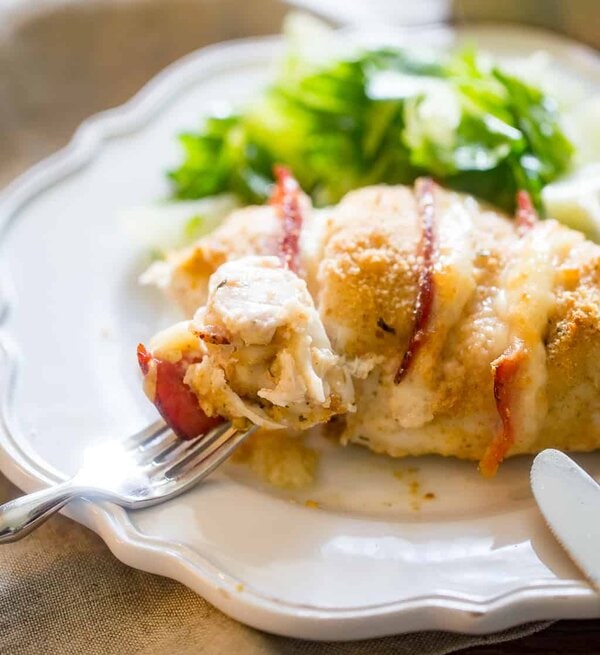 Taking a bite of baked chicken cordon bleu